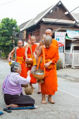 Luang Prabang, Laos - Mar 06 2015: sadaka sabah toplama Budist rahipler. Rahipler de Luang Prabang için sadaka verme geleneği turistlere genişletilmiş.