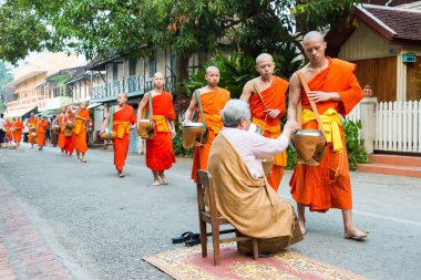 Luang Prabang, Laos - Mar 06 2015: sadaka sabah toplama Budist rahipler. Rahipler de Luang Prabang için sadaka verme geleneği turistlere genişletilmiş.