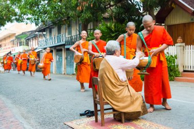 Luang Prabang, Laos - Mar 06 2015: sadaka sabah toplama Budist rahipler. Rahipler de Luang Prabang için sadaka verme geleneği turistlere genişletilmiş.