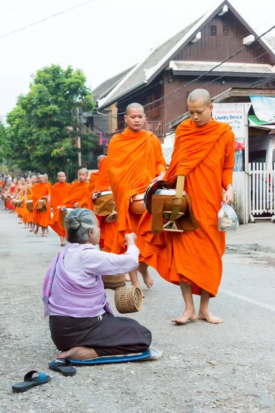 Luang Prabang, Laos - Mar 06 2015: Buddhistiska munkar samla allmosor på morgonen. Traditionen av allmosan till munkar i Luang Prabang har förlängts till turister. — Stockfoto