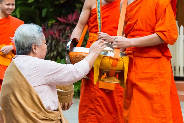 Luang Prabang, Laos - Mar 06 2015: Buddhistiska munkar samla allmosor på morgonen. Traditionen av allmosan till munkar i Luang Prabang har förlängts till turister. — Stockfoto