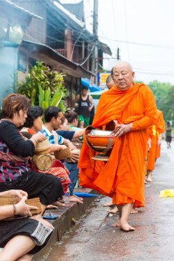Luang Prabang, Laos - 12 Haziran 2015: sabah töreni Budist sadaka. Rahipler de Luang Prabang için sadaka verme geleneği turistlere genişletilmiş.
