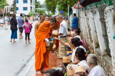 Luang Prabang, Laos - 12 Haziran 2015: sabah töreni Budist sadaka. Rahipler de Luang Prabang için sadaka verme geleneği turistlere genişletilmiş.