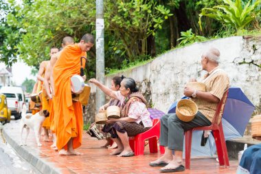 Luang Prabang, Laos - 12 Haziran 2015: sabah töreni Budist sadaka. Rahipler de Luang Prabang için sadaka verme geleneği turistlere genişletilmiş.