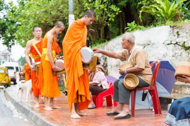 Luang Prabang, Laos - 12 Haziran 2015: sabah töreni Budist sadaka. Rahipler de Luang Prabang için sadaka verme geleneği turistlere genişletilmiş.