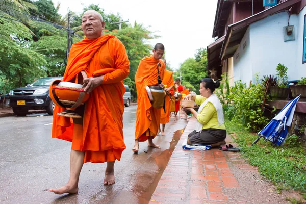 Luang Prabang, Laos - Jun 12 2015: Boeddhistische aalmoes geven ceremonie in de ochtend. De traditie van het geven van aalmoes aan monniken in Luang Prabang is uitgebreid tot toeristen. — Stockfoto