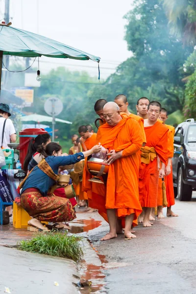 Luang Prabang, Laos - Jun 12 2015: Buddhistiska alms ger ceremoni på morgonen. Traditionen av allmosan till munkar i Luang Prabang har förlängts till turister. — Stockfoto