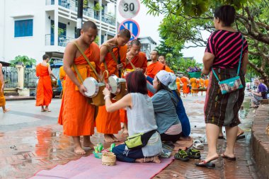 Luang Prabang, Laos - 12 Haziran 2015: sabah töreni Budist sadaka. Rahipler de Luang Prabang için sadaka verme geleneği turistlere genişletilmiş.