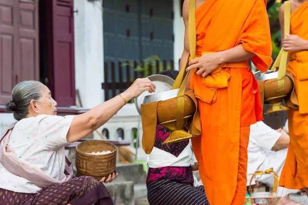 Luang Prabang, Laos - Jun 13 2015: Buddhistiska alms ger ceremoni på morgonen. Traditionen av allmosan till munkar i Luang Prabang har förlängts till turister. — Stockfoto