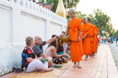 Luang Prabang, Laos - 13 Haziran 2015: sabah töreni Budist sadaka. Rahipler de Luang Prabang için sadaka verme geleneği turistlere genişletilmiş.