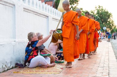 Luang Prabang, Laos - 13 Haziran 2015: sabah töreni Budist sadaka. Rahipler de Luang Prabang için sadaka verme geleneği turistlere genişletilmiş.