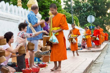 Luang Prabang, Laos - 13 Haziran 2015: sabah töreni Budist sadaka. Rahipler de Luang Prabang için sadaka verme geleneği turistlere genişletilmiş.