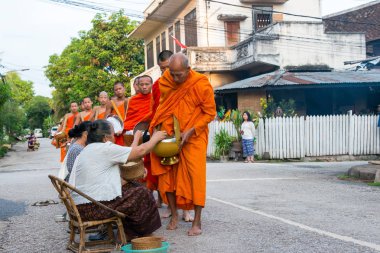 Luang Prabang, Laos - 13 Haziran 2015: sabah töreni Budist sadaka. Rahipler de Luang Prabang için sadaka verme geleneği turistlere genişletilmiş.