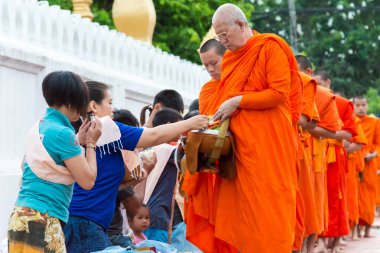 Luang Prabang, Laos - 14 Haziran 2015: sabah töreni Budist sadaka. Rahipler de Luang Prabang için sadaka verme geleneği turistlere genişletilmiş.