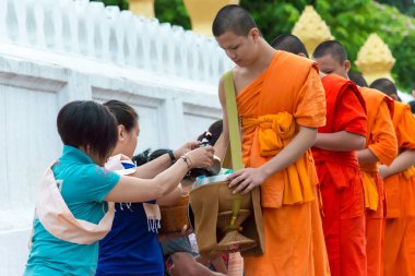 Luang Prabang, Laos - 14 Haziran 2015: sabah töreni Budist sadaka. Rahipler de Luang Prabang için sadaka verme geleneği turistlere genişletilmiş.