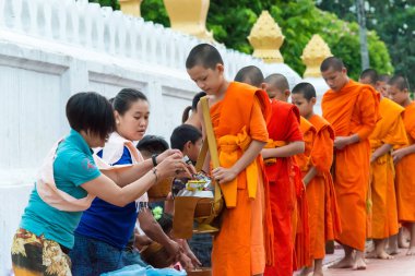 Luang Prabang, Laos - 14 Haziran 2015: sabah töreni Budist sadaka. Rahipler de Luang Prabang için sadaka verme geleneği turistlere genişletilmiş.