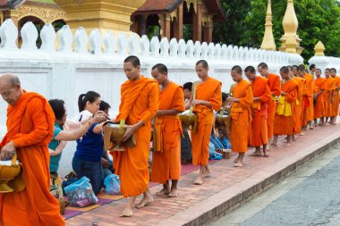 Luang Prabang, Laos - 14 Haziran 2015: sabah töreni Budist sadaka. Rahipler de Luang Prabang için sadaka verme geleneği turistlere genişletilmiş.