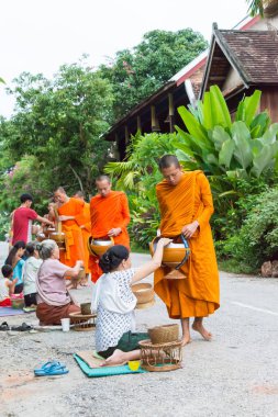 Luang Prabang, Laos - 14 Haziran 2015: sabah töreni Budist sadaka. Rahipler de Luang Prabang için sadaka verme geleneği turistlere genişletilmiş.