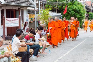 Luang Prabang, Laos - 14 Haziran 2015: sabah töreni Budist sadaka. Rahipler de Luang Prabang için sadaka verme geleneği turistlere genişletilmiş.