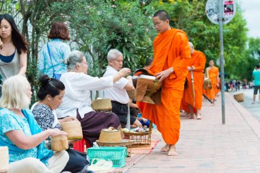 Luang Prabang, Laos - 15 Haziran 2015: sabah töreni Budist sadaka. Rahipler de Luang Prabang için sadaka verme geleneği turistlere genişletilmiş.
