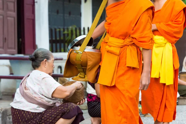 Luang Prabang, Laos - Jun 13 2015: Buddhistiska alms ger ceremoni på morgonen. Traditionen av allmosan till munkar i Luang Prabang har förlängts till turister. — Stockfoto