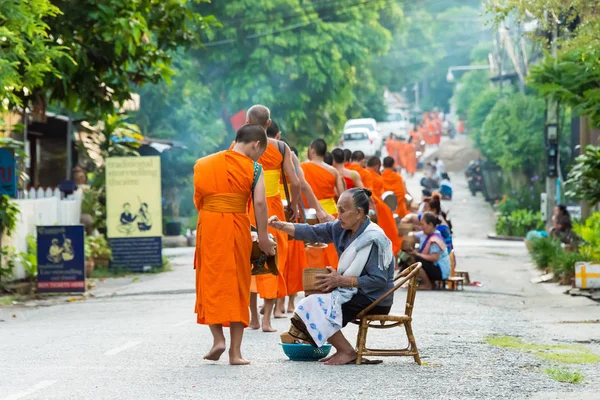 Luang Prabang, Laos - Jun 13 2015: Buddhistiska alms ger ceremoni på morgonen. Traditionen av allmosan till munkar i Luang Prabang har förlängts till turister. — Stockfoto