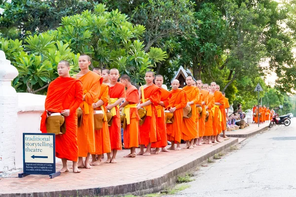 Luang Prabang, Laos - Jun 13 2015: Ceremonia de limosna budista por la mañana. La tradición de dar limosna a los monjes en Luang Prabang se ha extendido a los turistas . — Foto de Stock