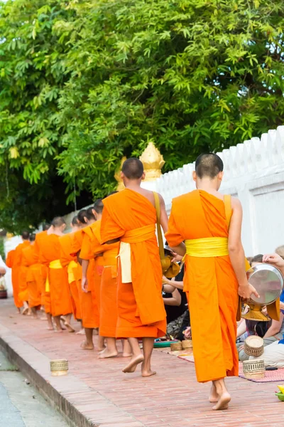 Luang prabang, laos - 13. Juni 2015: Buddhistische Almosen-Zeremonie am Morgen. die Tradition, Mönchen in luang prabang Almosen zu geben, wurde auf Touristen ausgeweitet. — Stockfoto