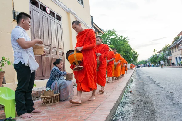 Luang Prabang, Laos - Jun 13 2015: Buddhistiska alms ger ceremoni på morgonen. Traditionen av allmosan till munkar i Luang Prabang har förlängts till turister. — Stockfoto