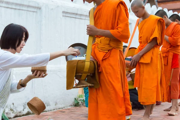Luang Prabang, Laos - 14. juni 2015: Buddhistiske almisser holder ceremoni om morgenen. Traditionen med at give almisser til munke i Luang Prabang er blevet udvidet til turister . - Stock-foto