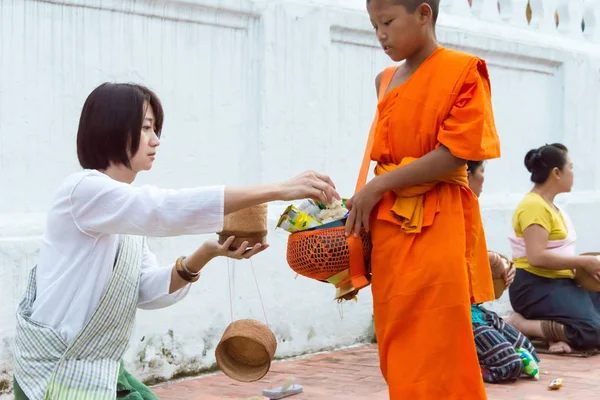 Luang Prabang, Laos - Jun 14 2015: Buddhistiska alms ger ceremoni på morgonen. Traditionen av allmosan till munkar i Luang Prabang har förlängts till turister. — Stockfoto