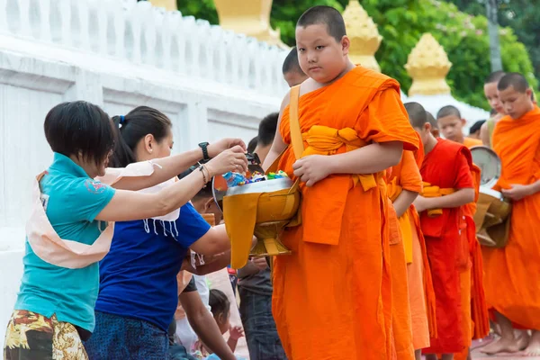 Luang Prabang, Laos - Jun 14 2015: Boeddhistische aalmoes geven ceremonie in de ochtend. De traditie van het geven van aalmoes aan monniken in Luang Prabang is uitgebreid tot toeristen. — Stockfoto