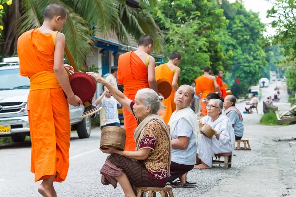 Luang Prabang, Laos - Jun 14 2015: Buddhistiska alms ger ceremoni på morgonen. Traditionen av allmosan till munkar i Luang Prabang har förlängts till turister. — Stockfoto