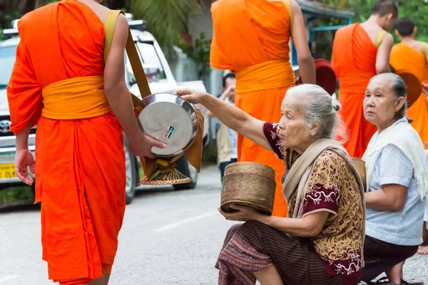 Luang Prabang, Laos - Jun 14 2015: Buddhistiska alms ger ceremoni på morgonen. Traditionen av allmosan till munkar i Luang Prabang har förlängts till turister. — Stockfoto