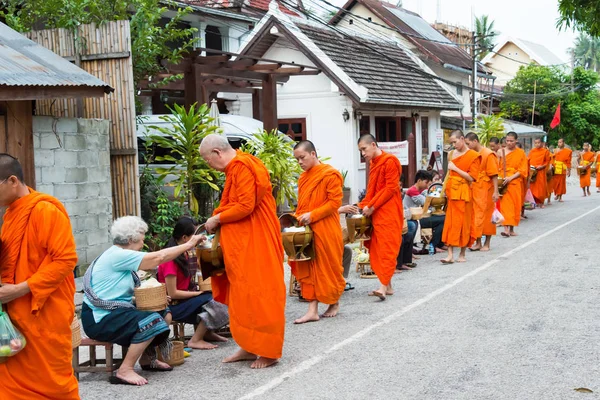 Luang Prabang, Laos - 14 Haziran 2015: sabah töreni Budist sadaka. Rahipler de Luang Prabang için sadaka verme geleneği turistlere genişletilmiş.