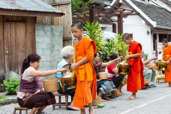 Луанг-Прабанг, Лаос - 14 июня 2015 г.: утром церемония раздачи буддийских милостынь. Традиция давать милостыню монахам в Луангпхабанге распространилась на туристов . — стоковое фото