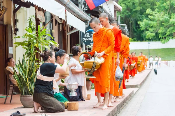 Luang Prabang, Laos - Jun 15 2015: Boeddhistische aalmoes geven ceremonie in de ochtend. De traditie van het geven van aalmoes aan monniken in Luang Prabang is uitgebreid tot toeristen. — Stockfoto