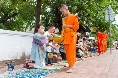 Luang Prabang, Laos - 15 Haziran 2015: sabah töreni Budist sadaka. Rahipler de Luang Prabang için sadaka verme geleneği turistlere genişletilmiş.
