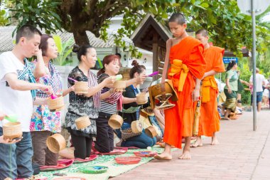 Luang Prabang, Laos - 15 Haziran 2015: sabah töreni Budist sadaka. Rahipler de Luang Prabang için sadaka verme geleneği turistlere genişletilmiş.