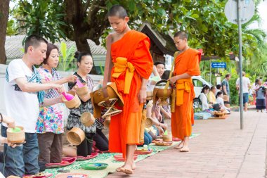 Luang Prabang, Laos - 15 Haziran 2015: sabah töreni Budist sadaka. Rahipler de Luang Prabang için sadaka verme geleneği turistlere genişletilmiş.