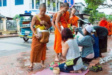 Luang Prabang, Laos - 12 Haziran 2015: sabah töreni Budist sadaka. Rahipler de Luang Prabang için sadaka verme geleneği turistlere genişletilmiş.
