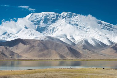 Doğu Türkistan, Çin - 21 Mayıs 2015: Karakul Gölü Mustagh Ata dağ. Pamir Dağları, Doğu Türkistan, Çin Akto İlçesi, Kızılsu Kırgız Özerk İli içinde Karakurum karayolu üzerinde ünlü bir manzara.