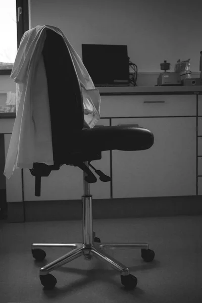 Пустой лабораторный стул с халатом — стоковое фото