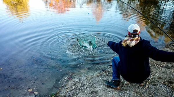 Fisherman with fishing rod and landing net — Stock Photo, Image