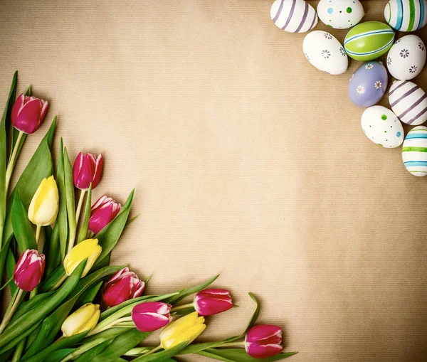 Východní vejce, tulipány na hnědý balicí papír — Stock fotografie