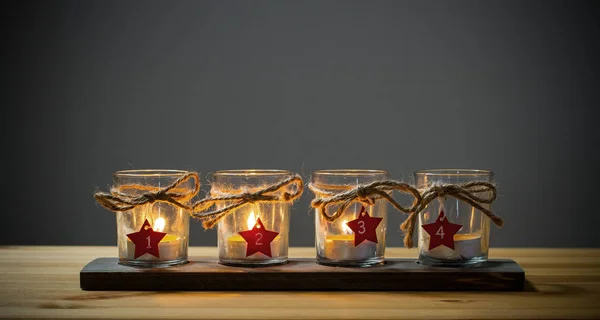 Четыре свечи Адвента на сером — стоковое фото