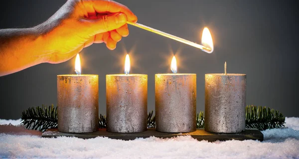 Enciende cuatro velas de adviento con fósforos —  Fotos de Stock