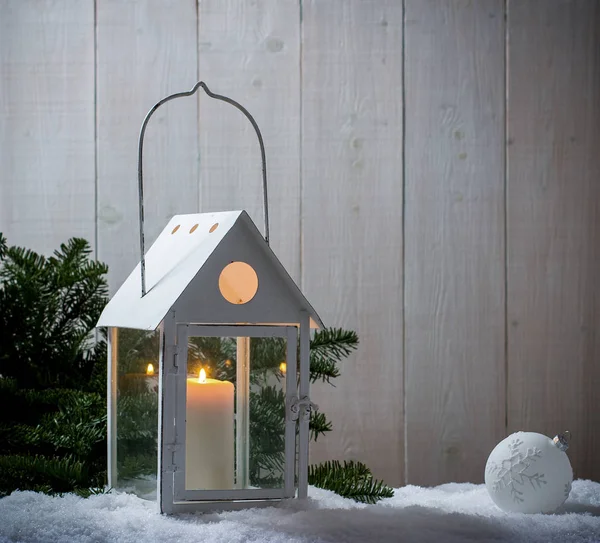 Lantern as house in snow with candle — Stock Photo, Image