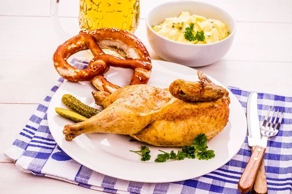 Полужареная курица, пиво, крендель и картофельный салат — стоковое фото