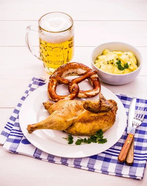 Meio frango assado, cerveja, pretzel e salada de batata — Fotografia de Stock